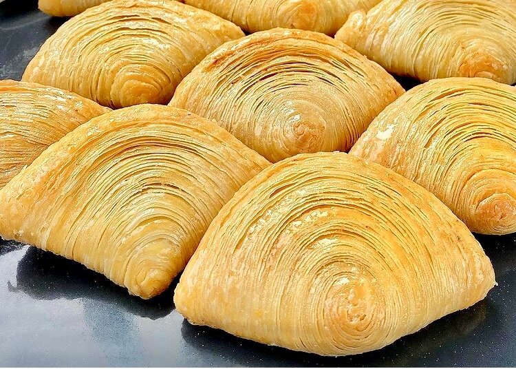  Складываю лепешки стопочкой, пересыпаю крахмалом — получается слоистая выпечка